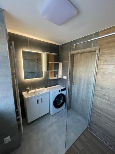 a bathroom with a washing machine and a sink at Apartmán Raj in Rajecké Teplice
