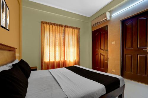 Un dormitorio con una cama y una ventana en Collection O KSRTC Bus Station Kottayam Formerly Hotel O Day Springs, en Kottayam