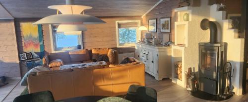 ein Wohnzimmer mit Couch und Ofen in der Unterkunft Hytteparadis ved Neidenelva in Neiden