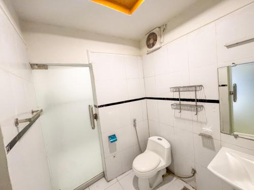 a white bathroom with a toilet and a shower at The Orchard Haven in Islamabad