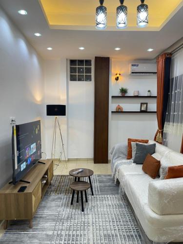 Una sala de estar con un sofá y un televisor en JAMARI Home, en Bonabéri