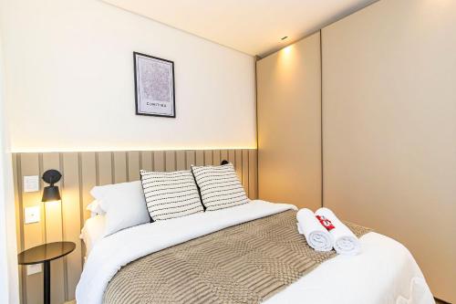 a bedroom with a bed with two towels on it at Apto em prédio com Piscina, Região Nobre - TEM0205 in Curitiba