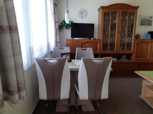 ein Zimmer mit einem Tisch mit Stühlen und einem Fernseher in der Unterkunft Ferienhaus "Lilienstein" in Prossen