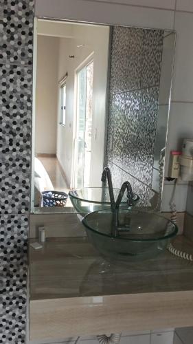 a bathroom with a glass bowl sink in front of a mirror at Rancho Serra do Ouro in Alexânia