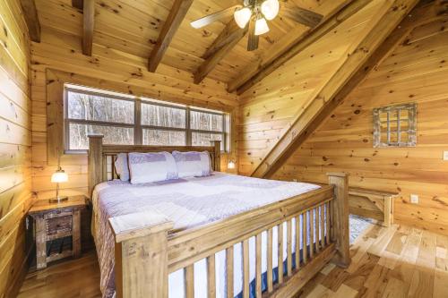 a bedroom with a bed in a log cabin at Elevated Cabin Bordering Smoky Mountain Nat'l Park in Bryson City