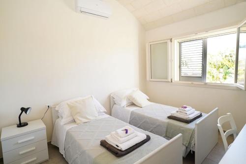 ein kleines Schlafzimmer mit zwei Betten und einem Fenster in der Unterkunft Villa Flora in Latiano