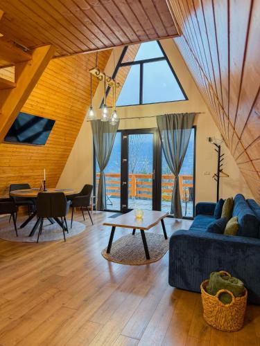 a living room with a blue couch and a table at Art A Cabin in Teşila