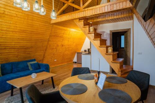 een woonkamer met een tafel en een blauwe bank bij Art A Cabin in Teşila