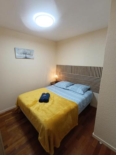 ein Schlafzimmer mit einem Bett mit blauem Hut darauf in der Unterkunft Refuge du Renard au Bord du Lac in Malbuisson