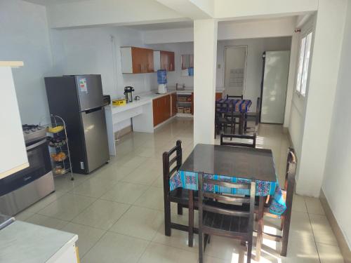 a kitchen and dining room with a table and chairs at Illariy Wasi Hostal in Arica