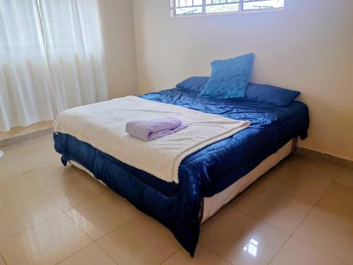 Una cama con sábanas azules y almohadas moradas. en Madalitso Guest House & Airport Services, en Lusaka