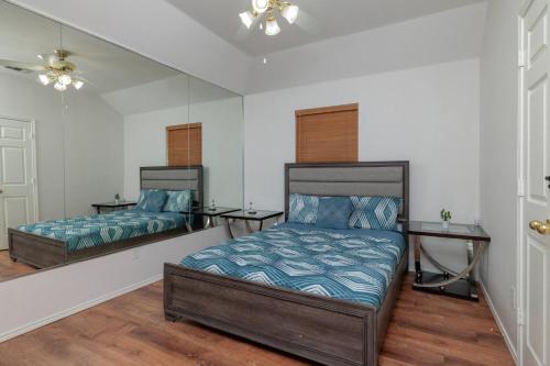 a bedroom with two beds and a mirror at Fenced Backyard - Workspace - Near DFW Airport in Euless