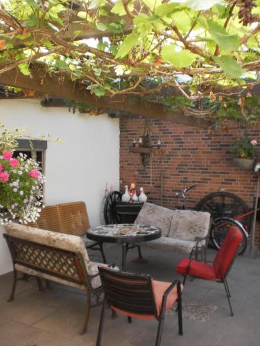 d'une terrasse avec un canapé, des chaises et une table. dans l'établissement Ländliche Ferienwohnung In Beliebtem Gästehaus, à Goosefeld
