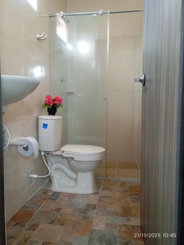 a bathroom with a toilet and a glass shower at Casa Juli in Santa Marta