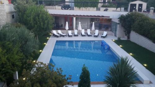 einen Blick über einen Pool mit Stühlen und ein Gebäude in der Unterkunft Helle Ferienwohnung im Erdgeschoss mit privater Terrasse - b57950 in Splitska