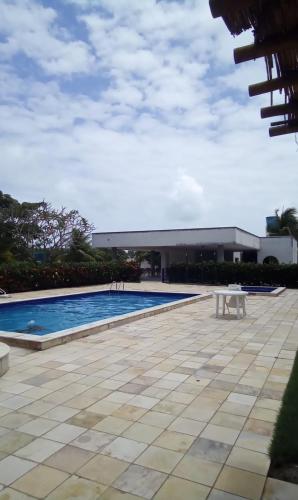 a swimming pool with a table in front of a building at Casa do Sonho in Paripueira
