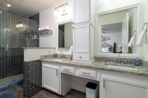 a bathroom with two sinks and a mirror at Private Pool - Game Room - Backyard TV - Fenced Yard in Plano