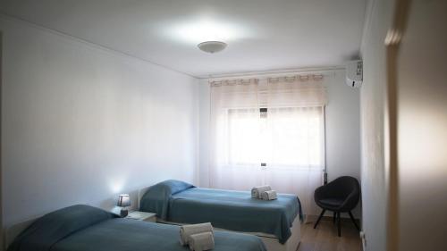 a small room with two beds and a window at Sister's House by east ALgarve guest in Tavira