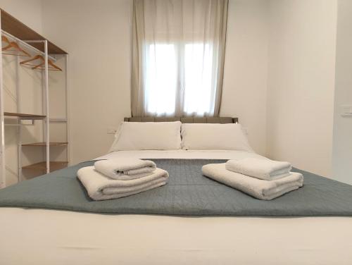Un dormitorio con una cama con toallas. en Baracca Space Apartments, en Florencia
