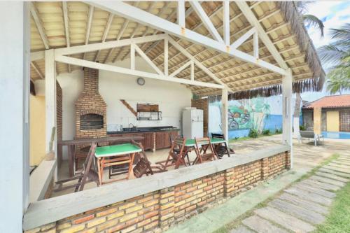 une cuisine extérieure avec un pavillon équipé de tables et de chaises dans l'établissement Home Beach Mar Conforto Self-Hosted, à Aquiraz