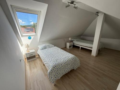 um quarto no sótão com duas camas e uma janela em Panoramic View em Postojna