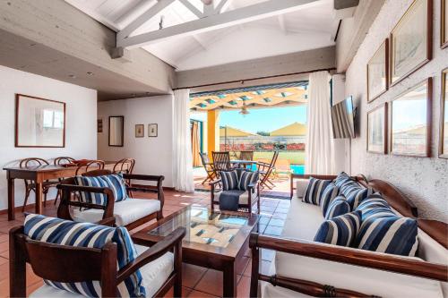 a living room with couches and a table and chairs at Barbati Beach - Villa Zante in Barbati