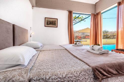 a bedroom with a large bed with a large window at Barbati Beach - Villa Zante in Barbati