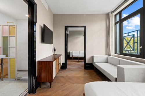 Una sala de estar con un sofá y un televisor en Freeman 303 by Rove - 1BR Condo with Shared Amenities, en Nueva York