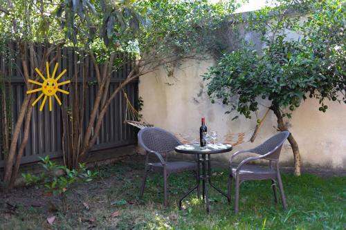 a table with two chairs and a bottle of wine at Home Hotel Kutaisi in Kutaisi