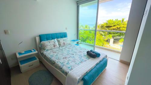 Estación El SaltoHermoso Apartamento Frente al Mar 3 Habitaciones MSC34的一间卧室设有蓝色的床和大窗户