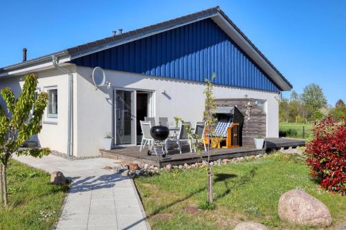 ein kleines weißes Haus mit einem Grill auf der Terrasse in der Unterkunft Ferienhaus La Mer in Altefähr