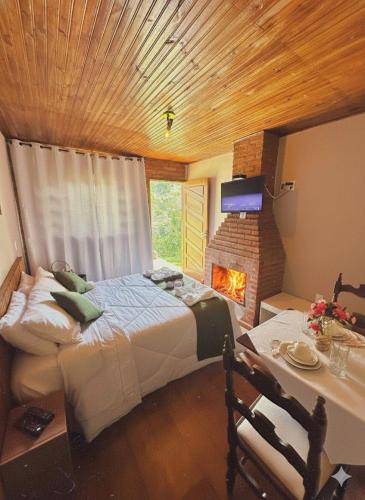 Un dormitorio con una cama grande y una chimenea. en Pousada All Green - Monte Verde, en Monte Verde