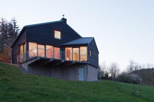 ein Haus auf einem grasbewachsenen Hügel in der Unterkunft Kleines Vulkaneifelhaus in Schutz