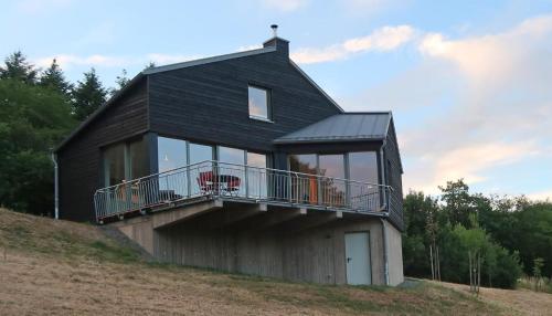 ein schwarzes Haus mit Balkon auf einem Hügel in der Unterkunft Kleines Vulkaneifelhaus in Schutz