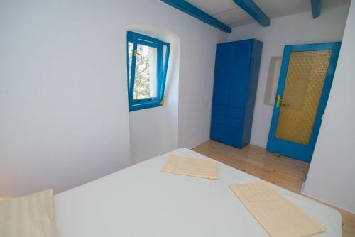 a room with white walls and blue doors at Haus Boris in Veli Lošinj