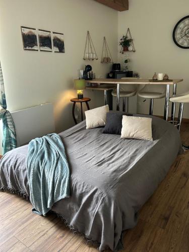 a large bed in a room with a kitchen at La maison du bonheur 17 in Marans