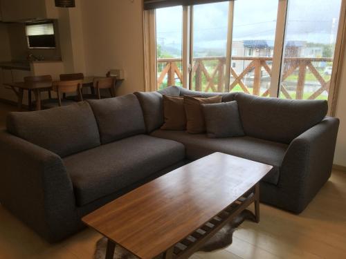 sala de estar con sofá y mesa de centro en Ume, en Furano