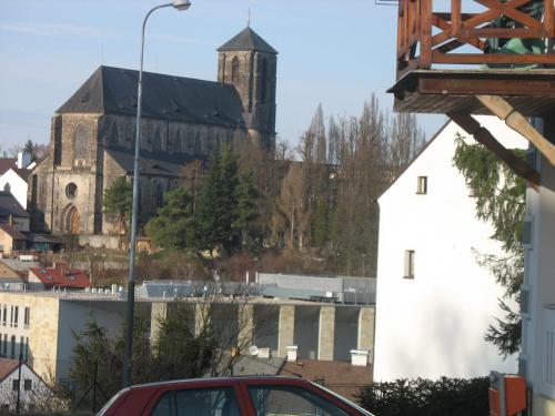 um carro vermelho está estacionado em frente a uma igreja em penzion - restaurace Na Výšince em Turnov