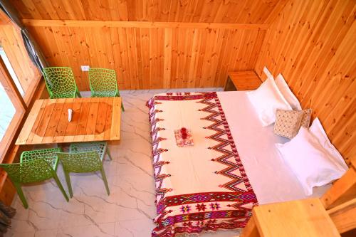 een kamer met een bed, een tafel en stoelen bij the clifton chapter tirthan in Banjār