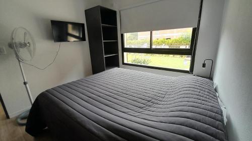 a small bedroom with a bed and a window at Los Curlis Dpto 2 Amb Las Gaviotas Mar Azul in Las Gaviotas