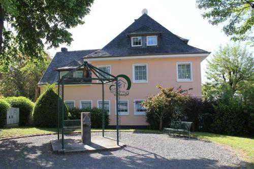 ein Spielplatz vor einem Haus mit einem Gebäude in der Unterkunft Ferienwohnung Vulkaneifel in Daun