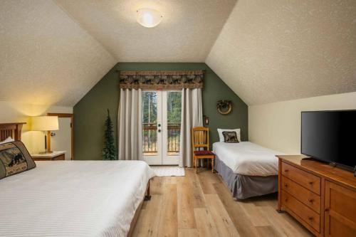 ein Schlafzimmer mit zwei Betten und einem Flachbildfernseher in der Unterkunft Alltitude Chalet in Government Camp