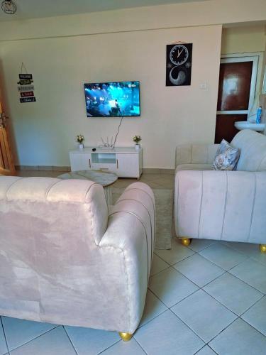 Una sala de estar con dos sofás y un televisor. en Evara staycation, en Shanzu