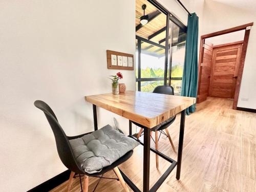 a dining room with a wooden table and two chairs at Finca Cacao in Pavones