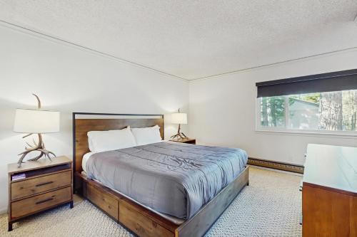 une chambre avec un grand lit et une fenêtre dans l'établissement Summit & Shore Chalet, à Wood Vista