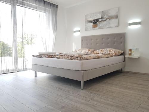 une chambre avec un lit avec une grande fenêtre dans l'établissement Ferienhaus Mit Privatem Pool In Ruhiger Lage, à Kaštel