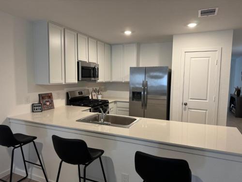 Una cocina con gabinetes blancos y un refrigerador de acero inoxidable. en new and beateful house, en Hockley