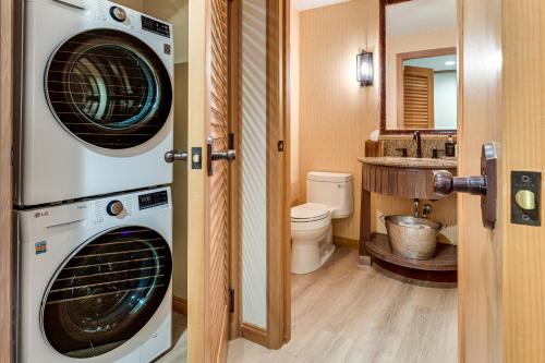 ein Badezimmer mit einer Waschmaschine und einem Trockner neben einem Waschbecken in der Unterkunft Luxe Cle Elum Condo with Mtn Views, Pool and Hot Tub in Roslyn