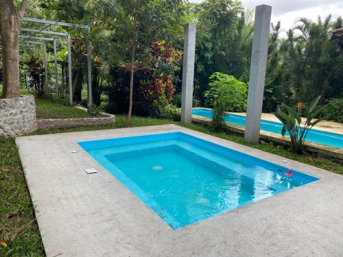 a swimming pool in a backyard with a blue pool at Casa Verapaz in Santa Catarina Palopó