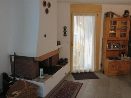 Una sala de estar con chimenea y una ventana. en Familie Frei, en Bever